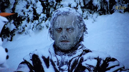 A Man With Ice On His Face Is Standing In The Snow With The Word Hdad In The Corner GIF