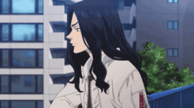 A Man With Long Black Hair Is Standing In Front Of A Building Looking Out The Window . GIF