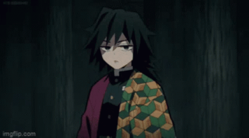 A Man With Long Black Hair Is Wearing A Green And Red Jacket And Making A Face . GIF