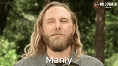 A Man With Long Blonde Hair And A Beard Is Smiling And Says Manly GIF