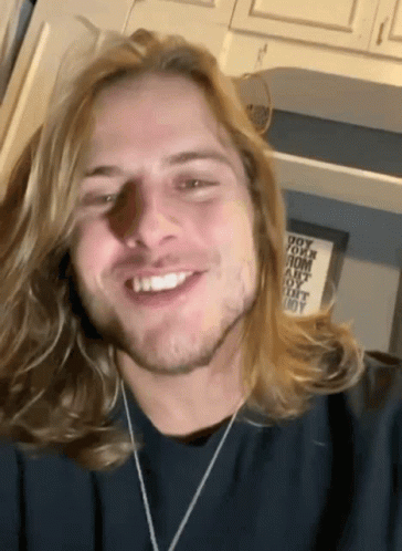 Man With Blonde Hair And Beard Smiling In Front Of Do Your Mom Sign GIF