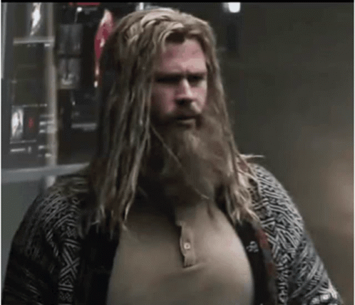 A Man With Long Blonde Hair And A Beard Is Wearing A Sweater . GIF