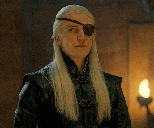 A Man With Long Blonde Hair And A Brown Eye Patch On His Forehead GIF