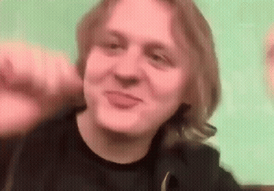 A Man With Long Blonde Hair Is Making A Funny Face While Making A Funny Face . GIF