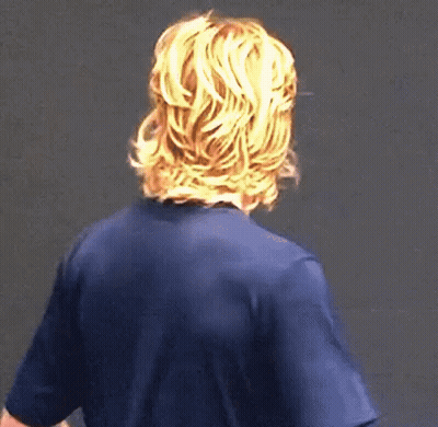A Man With Long Blonde Hair Is Wearing A Blue Shirt . GIF