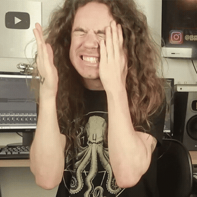 A Man With Long Curly Hair Covering His Face With His Hands GIF
