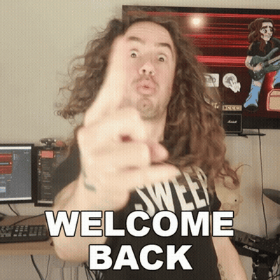 A Man With Long Curly Hair Is Pointing At The Camera With The Words Welcome Back Below Him GIF