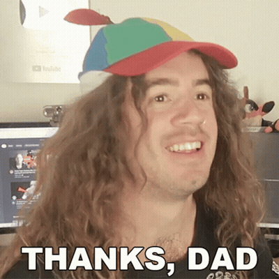 A Man With Long Curly Hair Is Wearing A Colorful Hat And Says Thanks Dad GIF