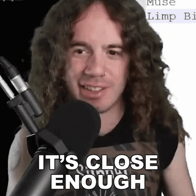A Man With Long Curly Hair Stands In Front Of A Microphone And Says It 'S Close Enough . GIF
