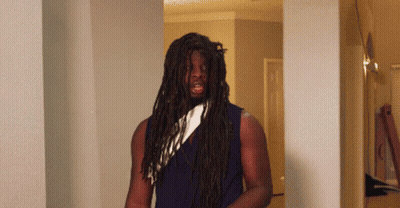 A Man With Long Dreadlocks And A White Scarf Around His Neck GIF
