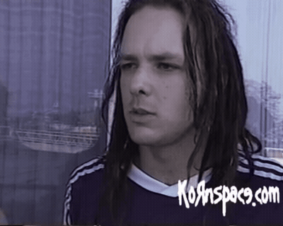 A Man With Long Dreadlocks Is Wearing A Shirt That Says Kornspace.com On It GIF
