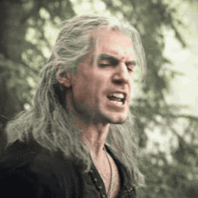 A Man With Long Gray Hair Is Making A Funny Face With His Mouth Open . GIF