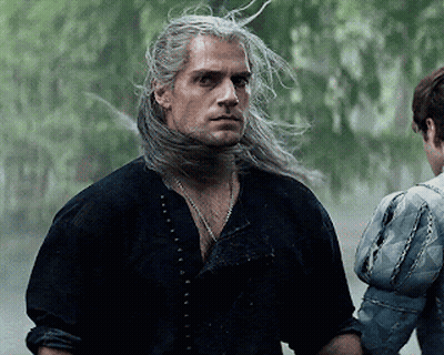 A Man With Long Gray Hair Is Standing Next To A Woman In A Blue Jacket . GIF