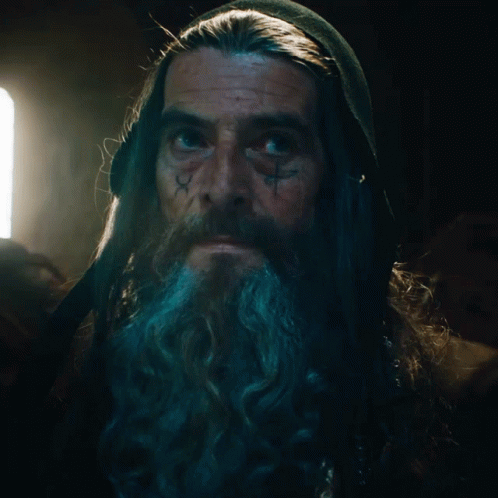 A Man With Long Hair And A Beard Has A Tattoo On His Face That Says ' X ' GIF