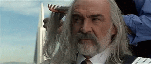 A Man With Long Hair And A Beard Is Getting His Hair Combed By A Man With A Comb . GIF