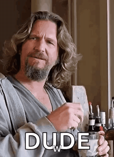 A Man With Long Hair And A Beard Is Holding A Cup Of Coffee And Drinking . GIF
