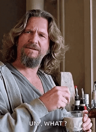 A Man With Long Hair And A Beard Is Holding A Cup Of Coffee And Saying Um , What ? GIF
