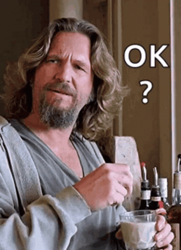 A Man With Long Hair And A Beard Is Holding A Glass Of Milk And A Cell Phone With The Word Ok On It GIF