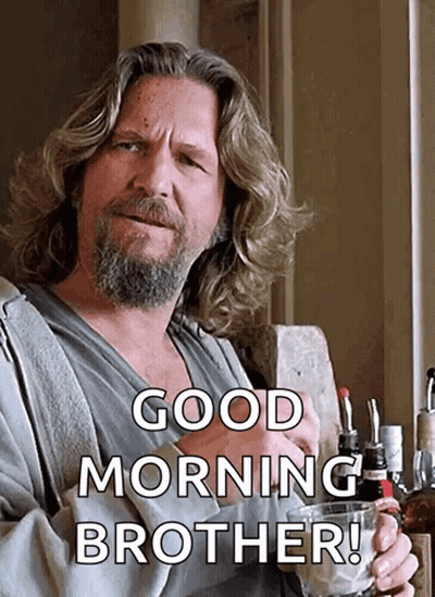 A Man With Long Hair And A Beard Is Holding A Glass Of Whiskey And Saying Good Morning Brother GIF