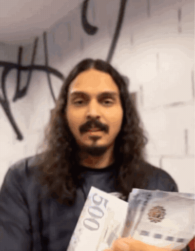 A Man With Long Hair And A Beard Is Holding Up A 500 Bill GIF