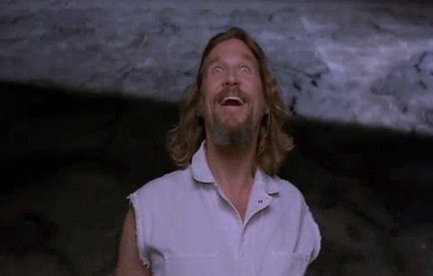 A Man With Long Hair And A Beard Is Laughing And Looking Up At The Sky . GIF