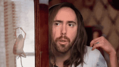 A Man With Long Hair And A Beard Is Looking At A Statue Of A Woman GIF
