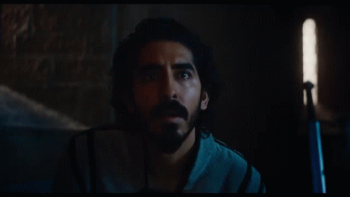 A Man With Long Hair And A Beard Is Looking At Something GIF