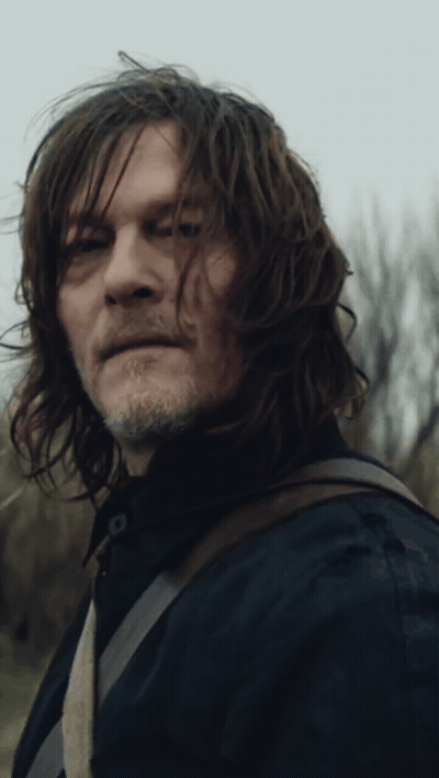 A Man With Long Hair And A Beard Is Looking At The Camera GIF