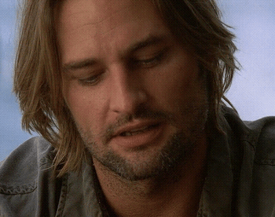 A Man With Long Hair And A Beard Is Looking Down With His Eyes Closed GIF