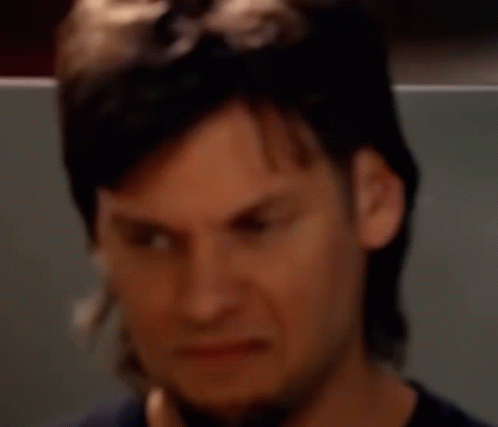 A Man With Long Hair And A Beard Is Making A Face GIF