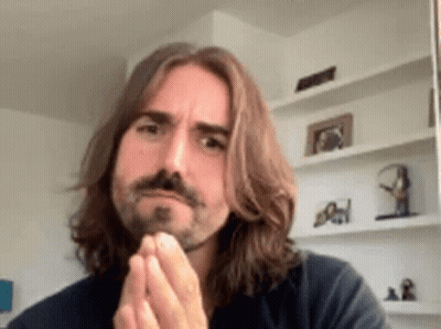 A Man With Long Hair And A Beard Is Making A Funny Face GIF