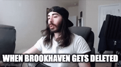 A Man With Long Hair And A Beard Is Sitting In A Chair With A Microphone . GIF
