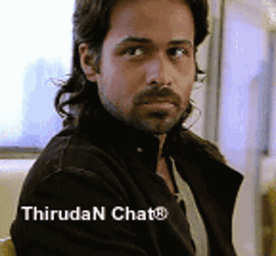 A Man With Long Hair And A Beard Is Sitting In A Chair With The Words Thiruda N Chat Written Below Him . GIF
