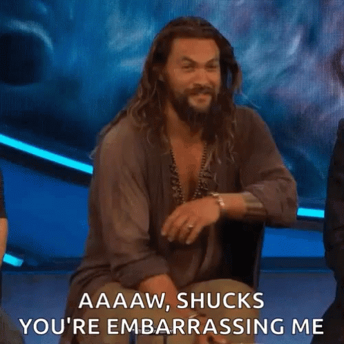 A Man With Long Hair And A Beard Is Sitting On A Stage And Talking To Someone . GIF