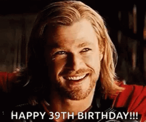 A Man With Long Hair And A Beard Is Smiling And Says Happy 39Th Birthday . GIF