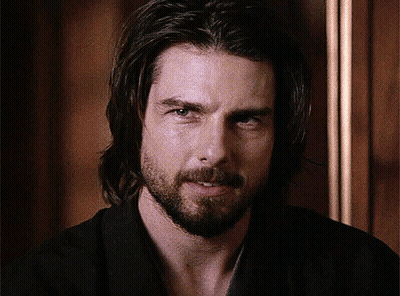 A Man With Long Hair And A Beard Is Smiling For The Camera GIF
