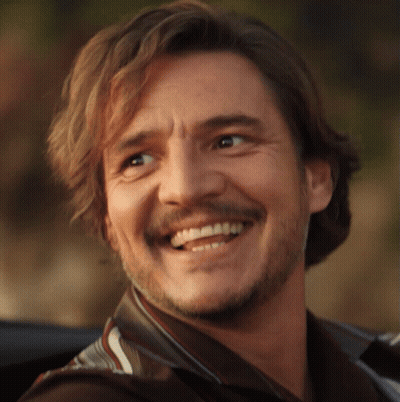 A Man With Long Hair And A Beard Is Smiling For The Camera GIF