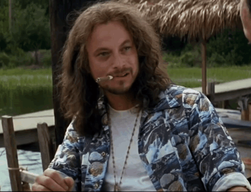 A Man With Long Hair And A Beard Is Smoking A Cigarette GIF