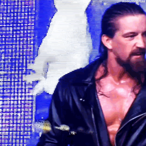 A Man With Long Hair And A Beard Is Standing In Front Of A Blue Background . GIF