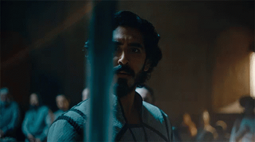A Man With Long Hair And A Beard Is Standing In Front Of A Crowd GIF
