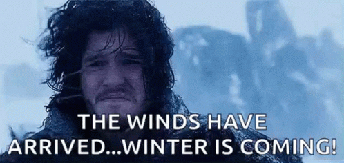 A Man With Long Hair And A Beard Is Standing In The Snow With The Words `` The Winds Have Arrived ... Winter Is Coming!  GIF