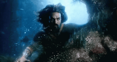 A Man With Long Hair And A Beard Is Swimming Underwater . GIF