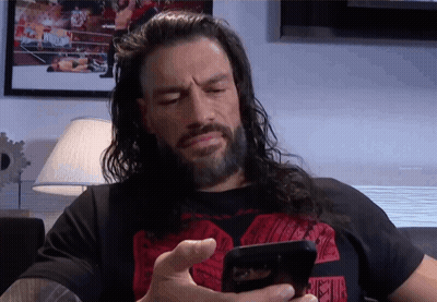 A Man With Long Hair And A Beard Is Using A Cell Phone GIF