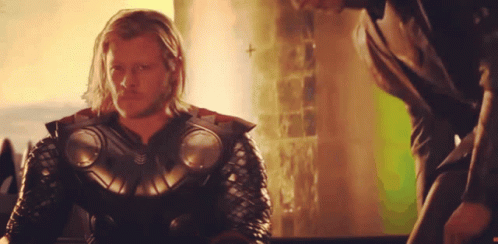 A Man With Long Hair And A Beard Is Wearing A Armored Suit GIF