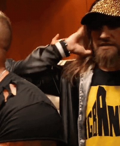 A Man With Long Hair And A Beard Is Wearing A Black And Yellow Shirt That Says Gear On It GIF