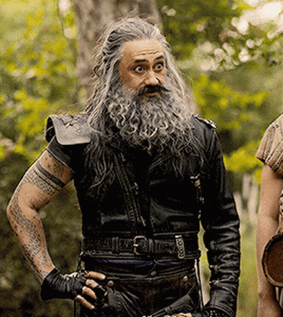 A Man With Long Hair And A Beard Is Wearing A Black Leather Jacket GIF