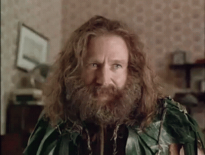 A Man With Long Hair And A Beard Is Wearing A Green Leafy Outfit . GIF