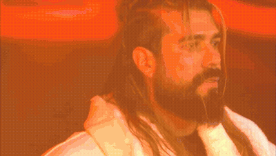 A Man With Long Hair And A Beard Is Wearing A Robe GIF