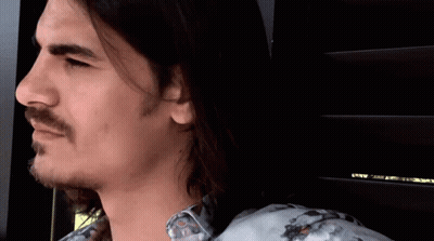 A Man With Long Hair And A Beard Is Wearing A Shirt With A Floral Pattern GIF