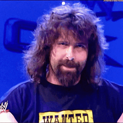 A Man With Long Hair And A Beard Is Wearing A Wanted T-Shirt GIF